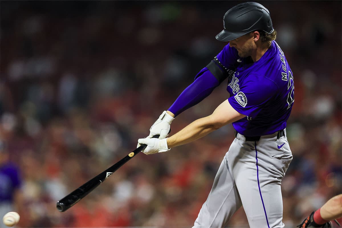 Colorado Rockies designated hitter Ryan McMahon (24) hits a single against the Cincinnati Reds in the ninth inning at Great American Ball Park.