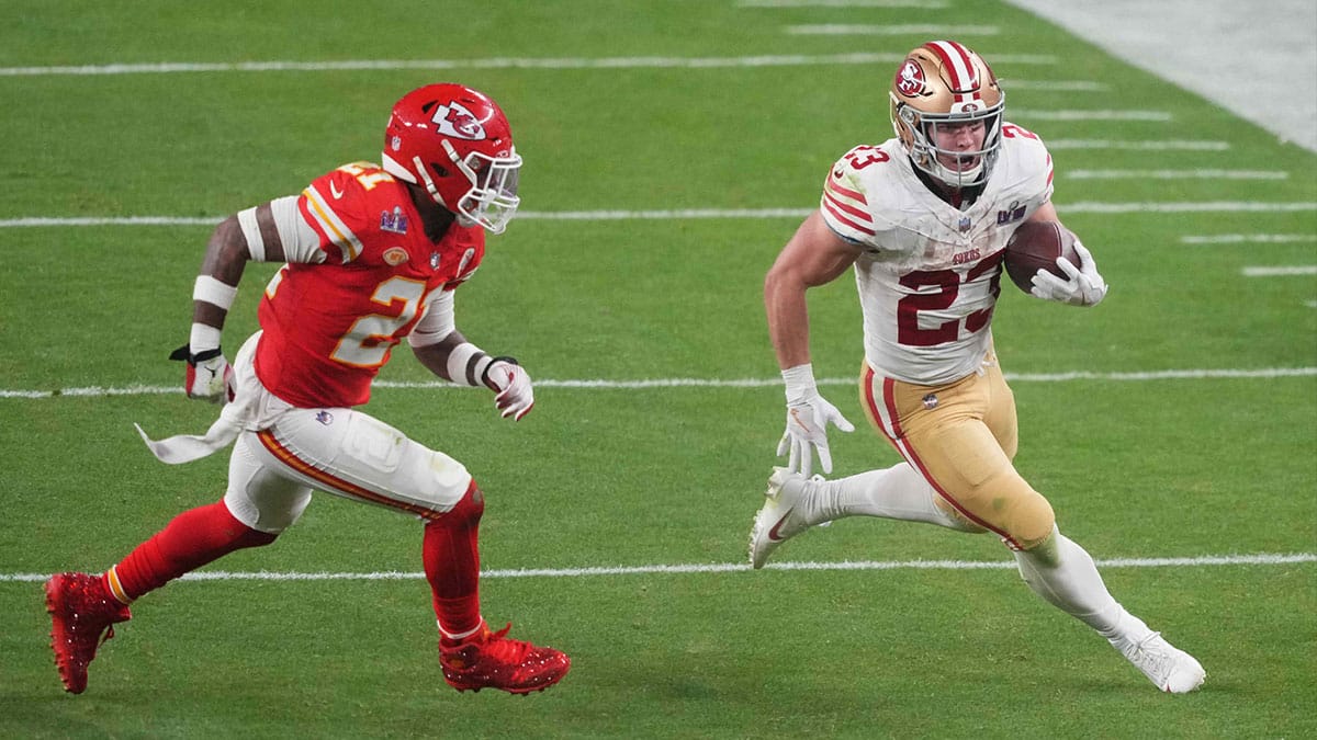 San Francisco 49ers running back Christian McCaffrey (23) runs with the ball against Kansas City Chiefs safety Mike Edwards (21) during overtime of Super Bowl LVIII at Allegiant Stadium. 