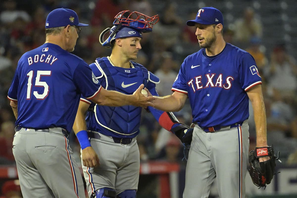 Texas Rangers catcher Andrew Knizner (12) looks on as manager Bruce Bochy (15) pulls starting pitcher Max Scherzer (31) in the seventh inning against the Los Angeles Angels at Angel Stadium.