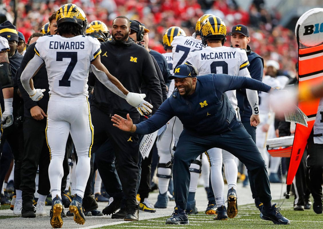 Michigan co-offensive coordinator Sherrone Moore high fives running back Donovan Edwards (7) after Edwards's scored a touchdown against Ohio State during the second half