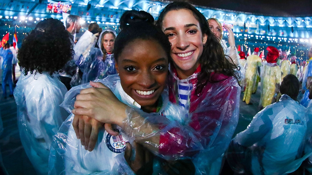 Aug 21, 2016; Rio de Janeiro, Brazil; Simone Biles and Aly Raisman (USA) wear ponchos during the heroes of the games procession during the closing ceremonies for the Rio 2016 Summer Olympic Games at Maracana. Mandatory Credit: Rob Schumacher-USA TODAY Sports