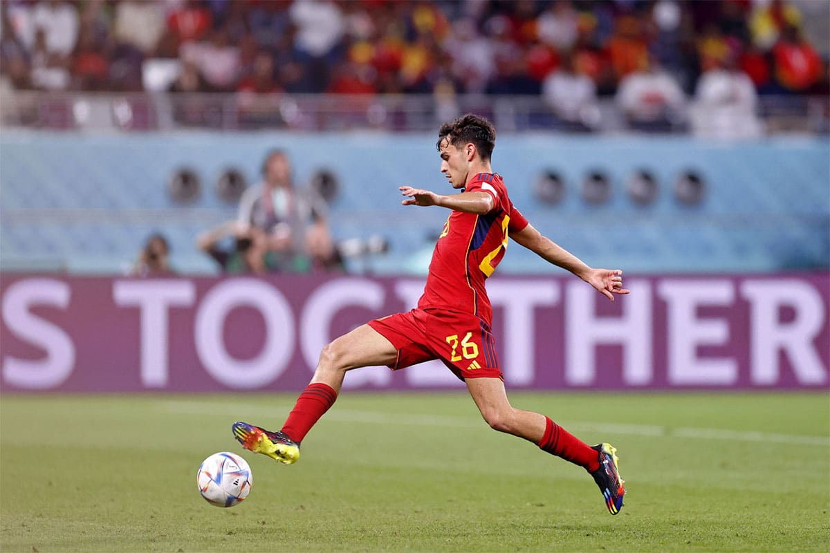 Spain midfielder Pedri (26) reaches for the ball against Japan during the second half of a group stage match during the 2022 World Cup at Khalifa International Stadium. 