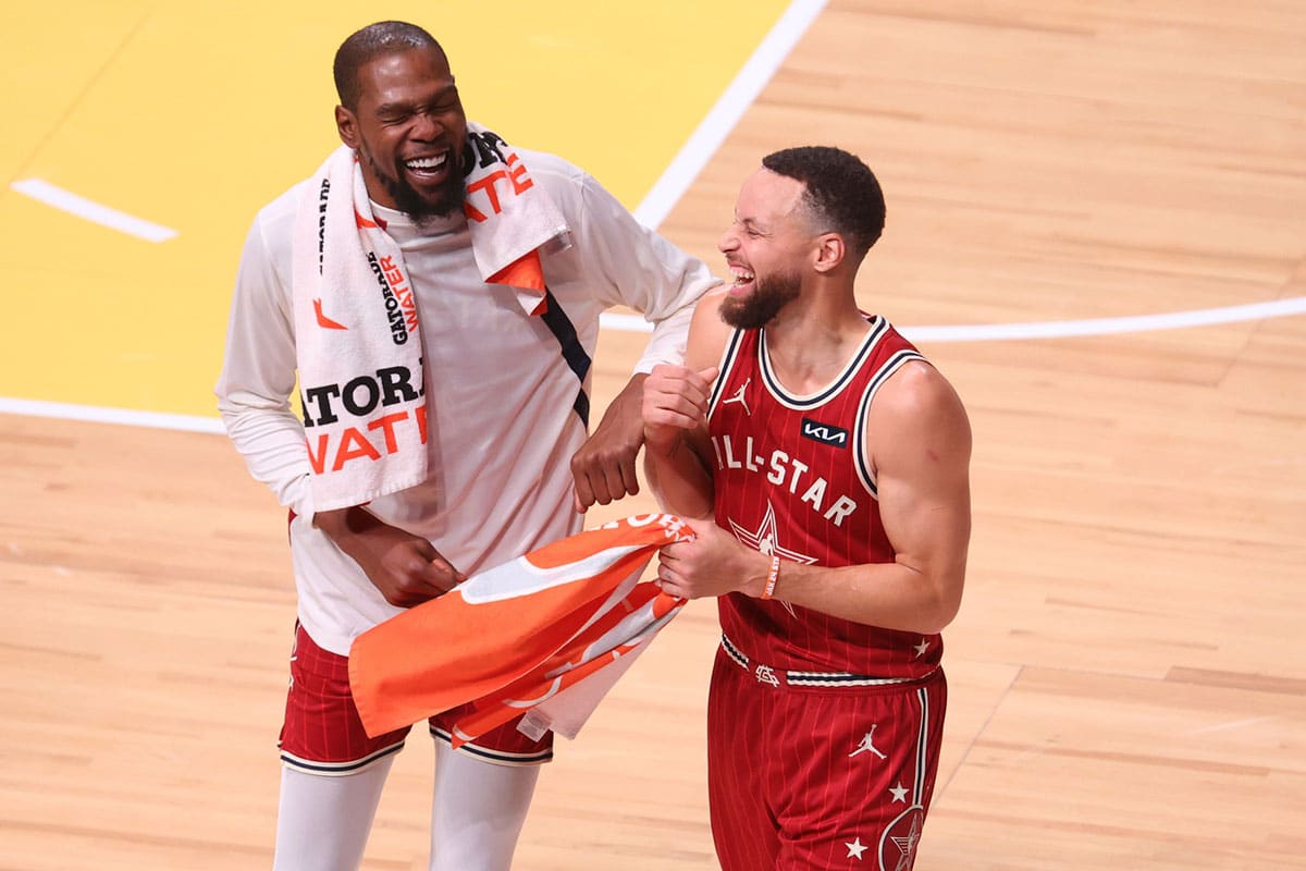 Western Conference forward Kevin Durant (35) of the Phoenix Suns and guard Stephen Curry (30) of the Golden State Warriors react after the third quarter against the Western Conference All-Stars in the 73rd NBA All Star game at Gainbridge Fieldhouse.