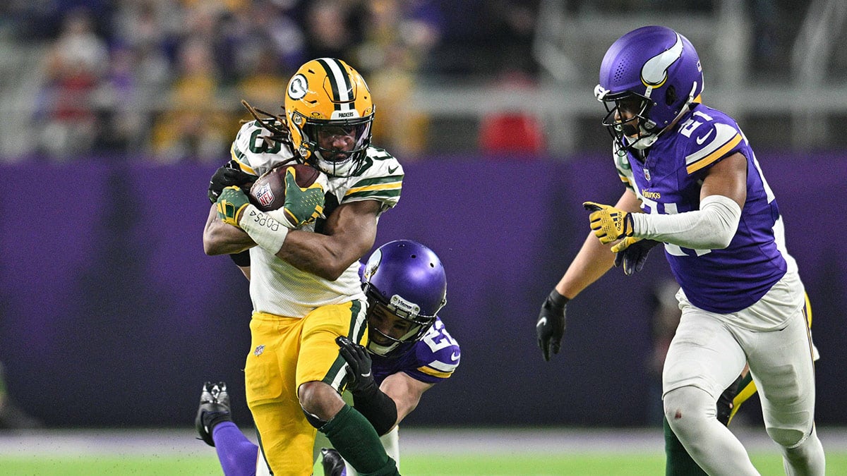 Green Bay Packers running back Aaron Jones (33) is pursued by Minnesota Vikings safety Harrison Smith (22) and cornerback Akayleb Evans (21) as tight end Ben Sims (89) blocks during the game at U.S. Bank Stadium. 