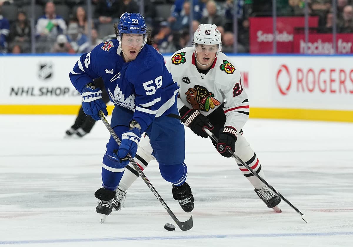 Toronto Maple Leafs left wing Tyler Bertuzzi (59) battles for the puck with Chicago Blackhawks left wing Lukas Reichel (27) during the third period at Scotiabank Arena.