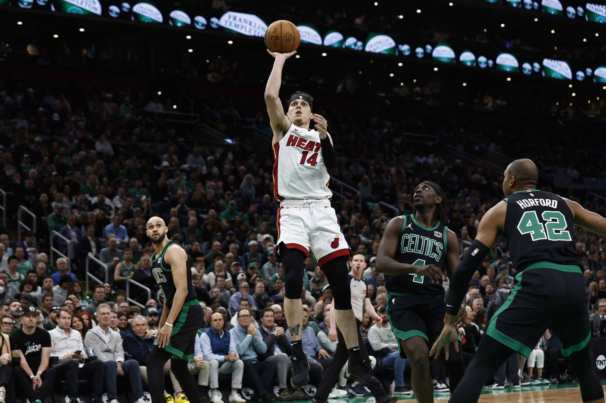 Miami Heat guard Tyler Herro (14) shoots as Boston Celtics guard Jrue Holiday (4) looks on during the first quarter of game five of the first round of the 2024 NBA playoffs at TD Garden.