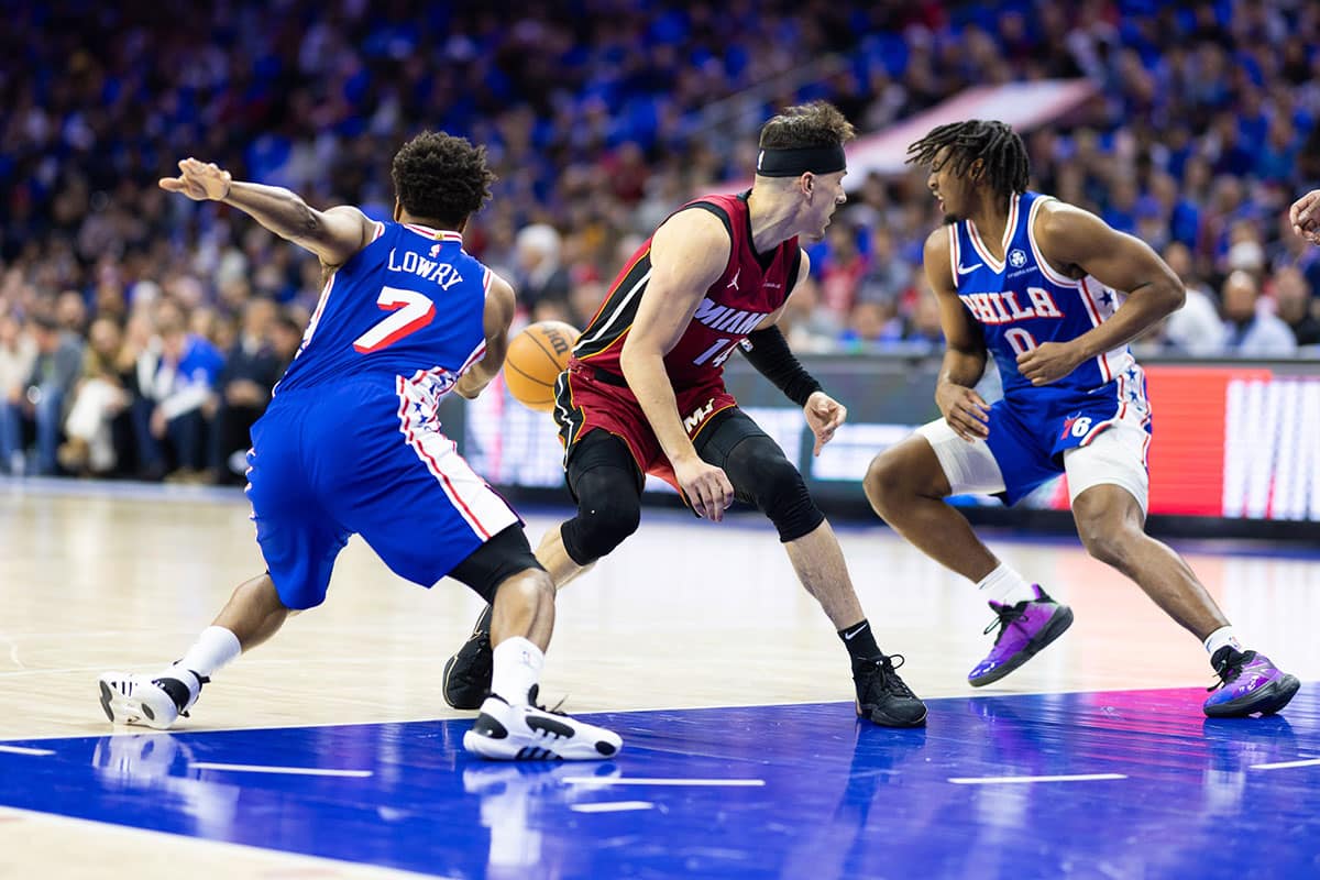 Philadelphia 76ers guard Kyle Lowry (7) and guard Tyrese Maxey (0) take the ball away from Miami Heat guard Tyler Herro (14) during the first quarter of a play-in game of the 2024 NBA playoffs at Wells Fargo Center.