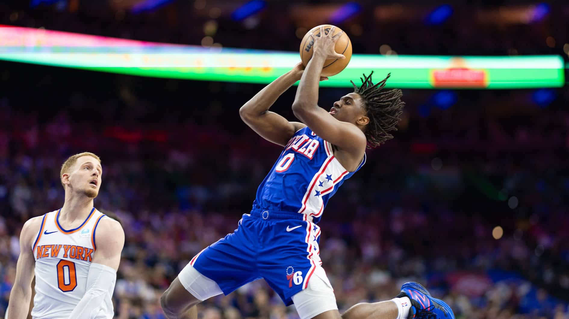 Philadelphia, Pennsylvania, USA; Philadelphia 76ers guard Tyrese Maxey (0) drives for a shot in front of New York Knicks guard Donte DiVincenzo (0) during game six of the first round for the 2024 NBA playoffs at Wells Fargo Center.