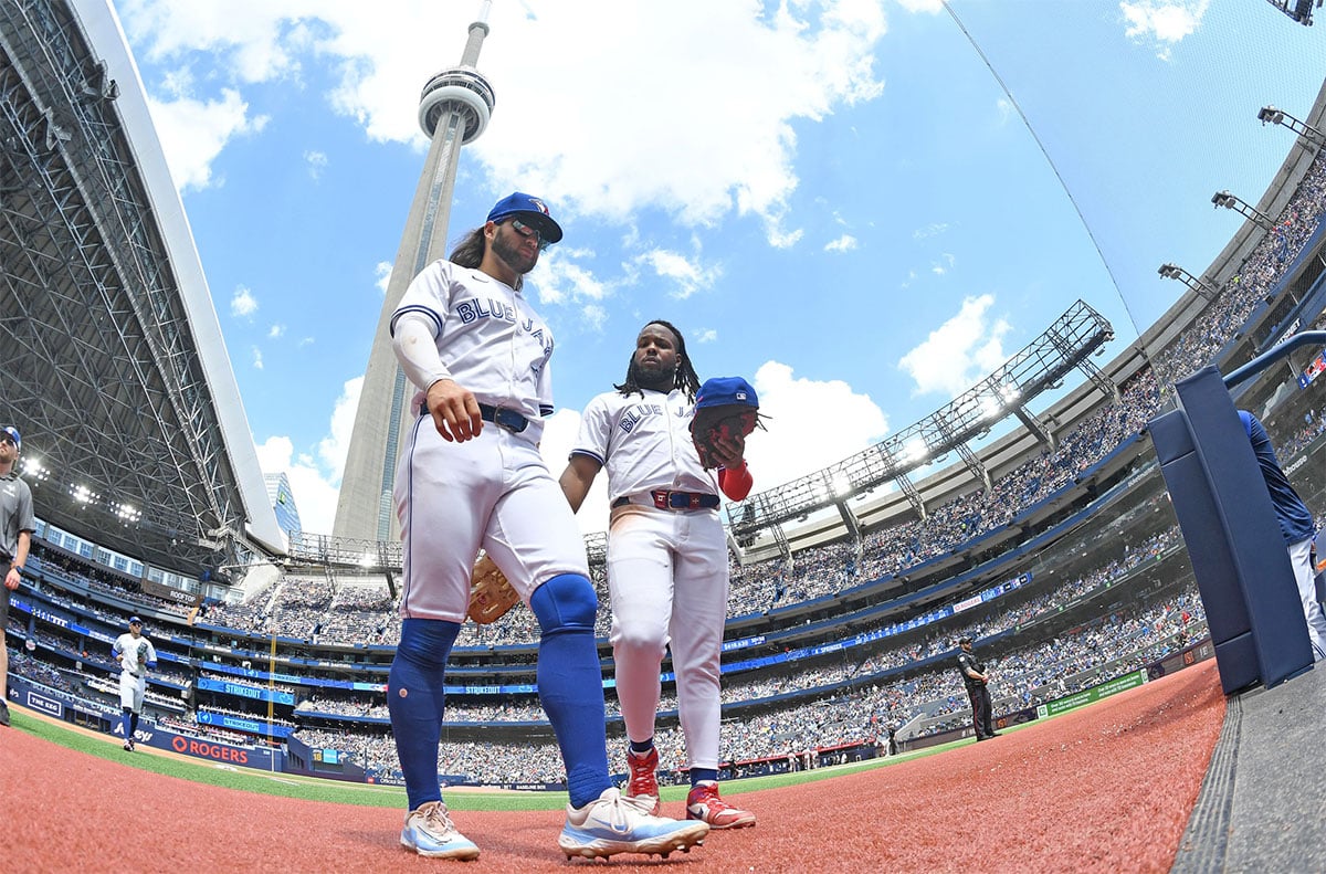 Jun 6, 2024; Toronto, Ontario, CAN; Toronto Blue Jays shortstop Bo Bichette (11, left) and first baseman Vladimir Guerrero Jr. (27) return to the dugout in the sixth inning against the Baltimore Orioles at Rogers Centre. 