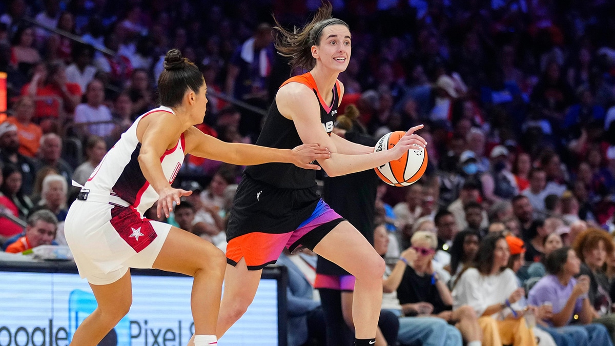WNBA Team guard Caitlin Clark drives against USA Team guard Kelsey Plum