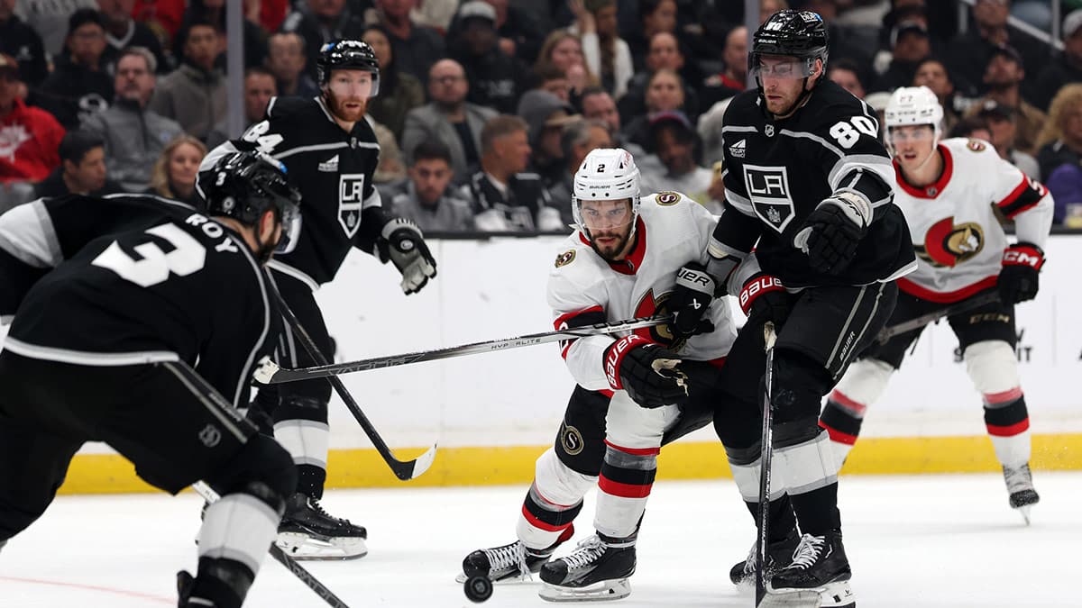 Ottawa Senators defenseman Artem Zub (2) fights for the puck against Los Angeles Kings defenseman Matt Roy (3) and center Pierre-Luc Dubois (80) during the third period at Crypto.com Arena.