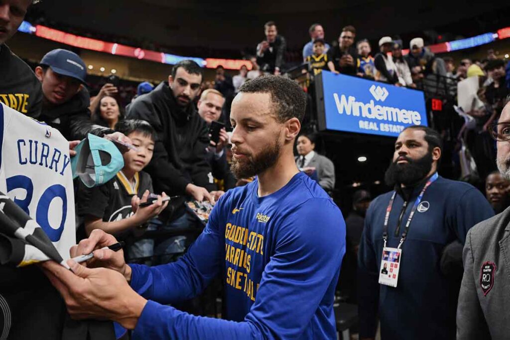 Golden State Warriors guard Stephen Curry (30) signs autographs for fans before a game against the Portland Trail Blazers at Moda Center. 