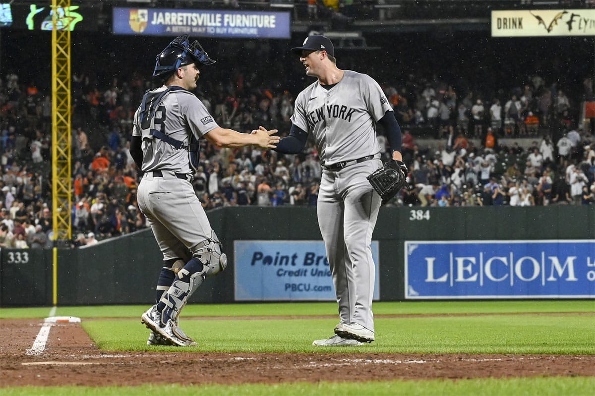 New York Yankees pitcher Clay Holmes (35) celebrates withcatcher Jose Trevino (39) after the game against the Baltimore Orioles at Oriole Park at Camden Yards. 