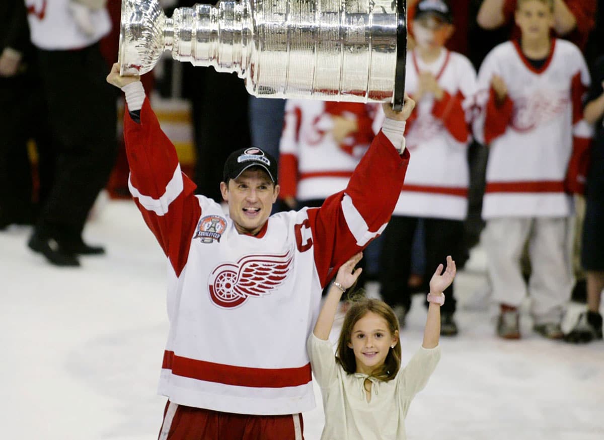 Steve Yzerman holds up the Stanley Cup with his daughter Isabella after winning the cup for the third time in 2002.