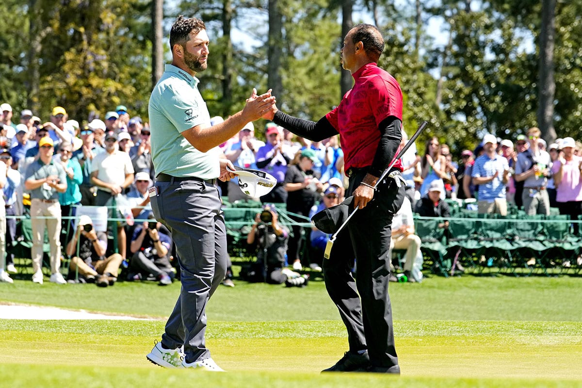 Tiger Woods shakes hands with Jon Rahm on the 18th green during the final round of the Masters golf tournament