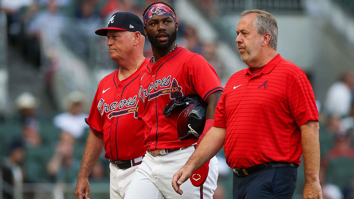 Atlanta Braves manager Brian Snitker (43) and center fielder Michael Harris II (23) walks off the field with assistant athletic trainer Jeff Stephenson after an injury against the Tampa Bay Rays in the first inning at Truist Park.