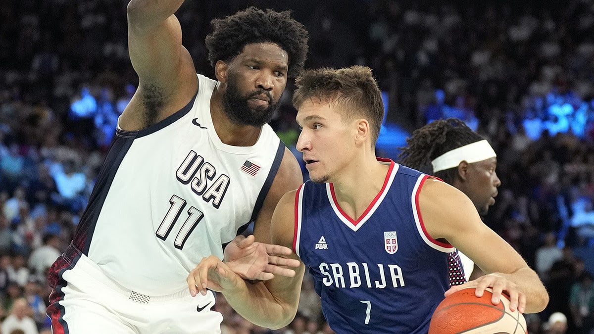 Serbia shooting guard Bogdan Bogdanovic (7) dribbles the ball while defended by United States centre Joel Embiid (11) during the first half in a men's basketball semifinal game during the Paris 2024 Olympic Summer Games at Accor Arena.