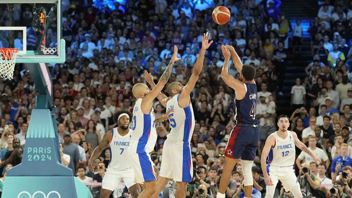 United States shooting guard Stephen Curry (4) shoots against France small forward Nicolas Batum (5) and shooting guard Evan Fournier (10) in the second half against France in the men's basketball gold medal game during the Paris 2024 Olympic Summer Games at Accor Arena.