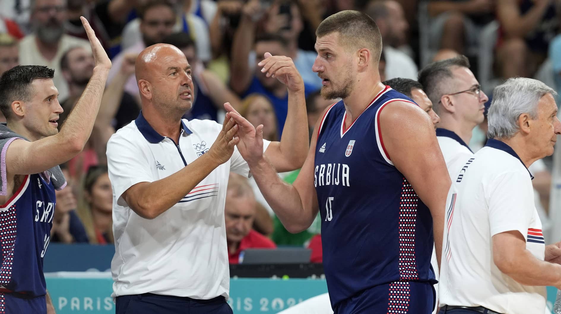 Nikola Jokic (15) celebrates with coaches and teammates