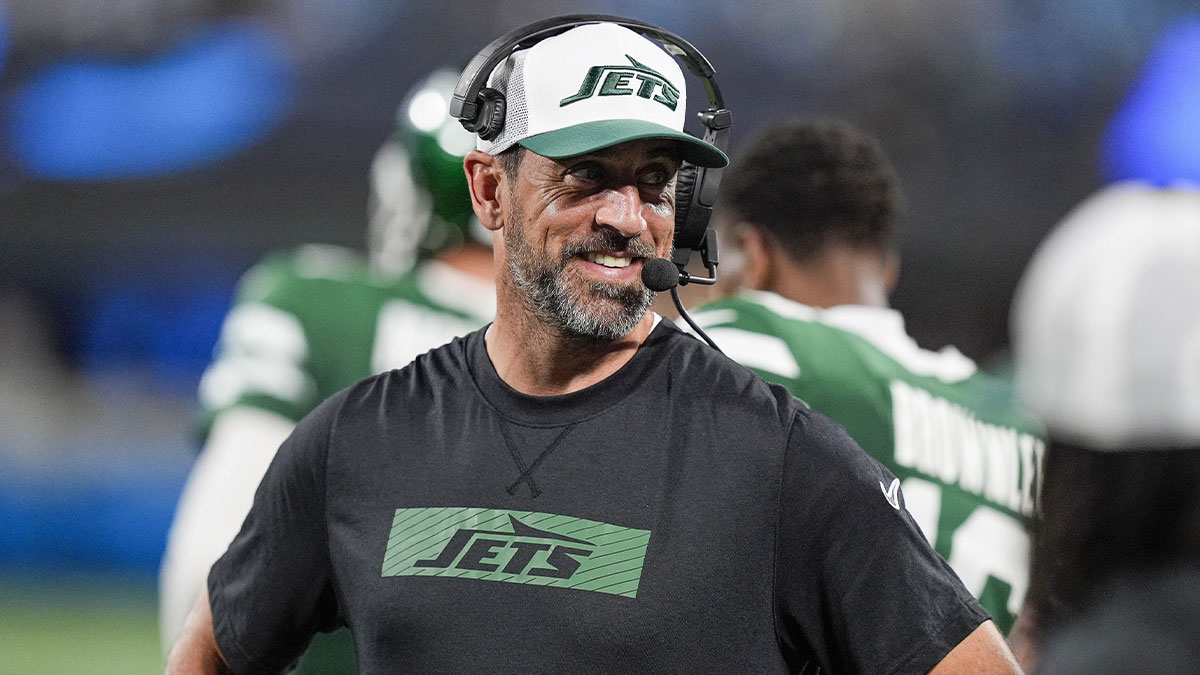 New York Jets quarterback Aaron Rodgers (8) shares a laugh on the sidelines during the second half against the Carolina Panthers at Bank of America Stadium