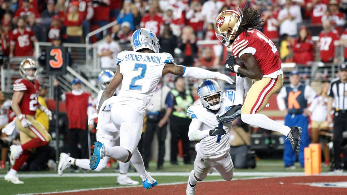 49ers wide receiver Brandon Aiyuk catches the ball around Lions defensive backs C.J. Gardner-Johnson, left, and Cam Sutton for a touchdown in the third quarter of the Lions' 34-31 loss in the NFC championship game in Santa Clara, California, on Jan. 28, 2024.