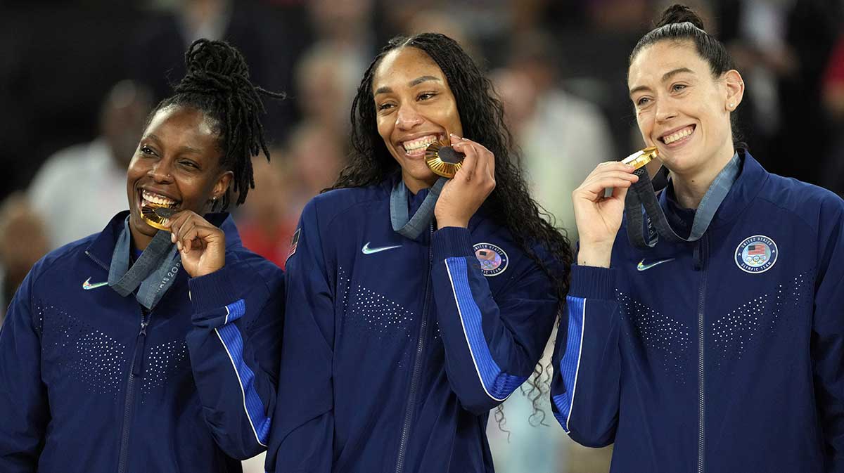 United States guard Chelsea Gray (8) and forward A'Ja Wilson (9) and power forward Breanna Stewart (10) celebrates on the podium after defeating France in the women's gold medal game during the Paris 2024 Olympic Summer Games at Accor Arena.