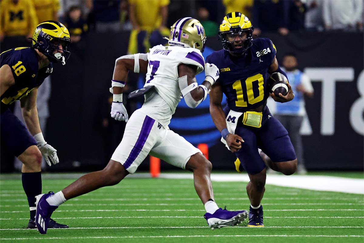 Michigan Wolverines quarterback Alex Orji (10) runs the ball against Washington Huskies cornerback Dominique Hampton (7) during the second quarter in the 2024 College Football Playoff national championship game at NRG Stadium.