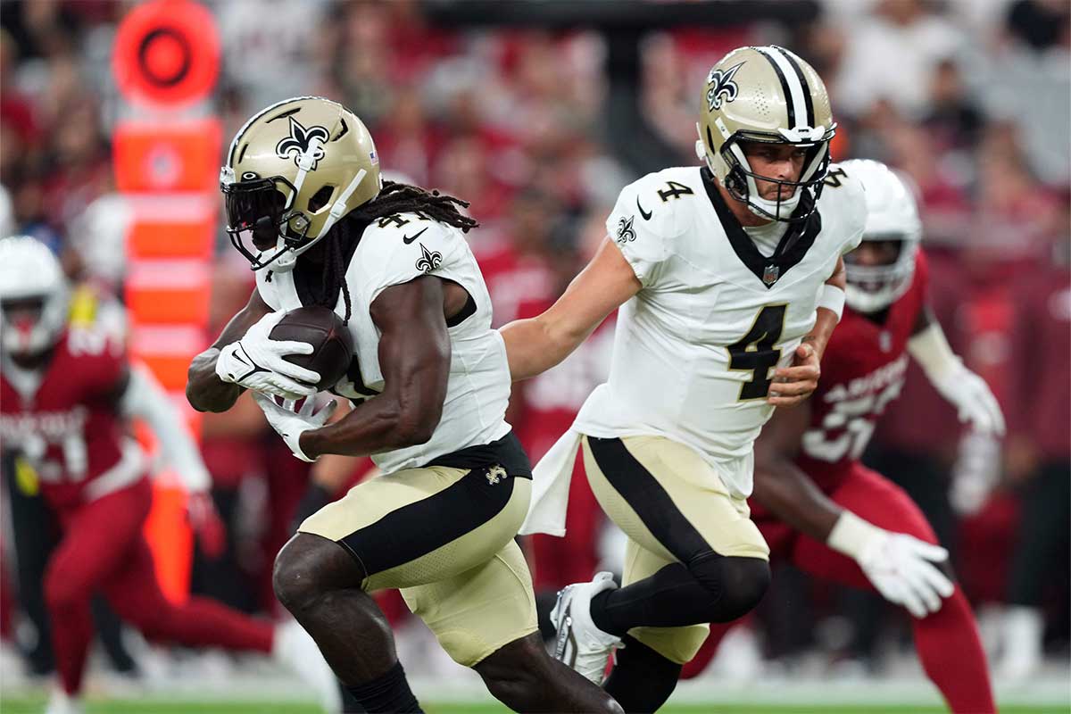 New Orleans Saints quarterback Derek Carr (4) hands the ball to New Orleans Saints running back Alvin Kamara (41) during the first half against the Arizona Cardinals at State Farm Stadium.