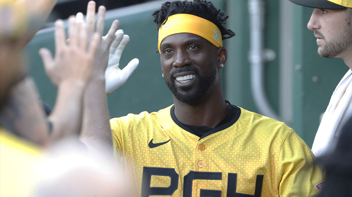 Jul 19, 2024; Pittsburgh, Pennsylvania, USA; Pittsburgh Pirates designated hitter Andrew McCutchen (22) celebrates in the dugout after scoring a run against the Philadelphia Phillies during the first inning at PNC Park. 