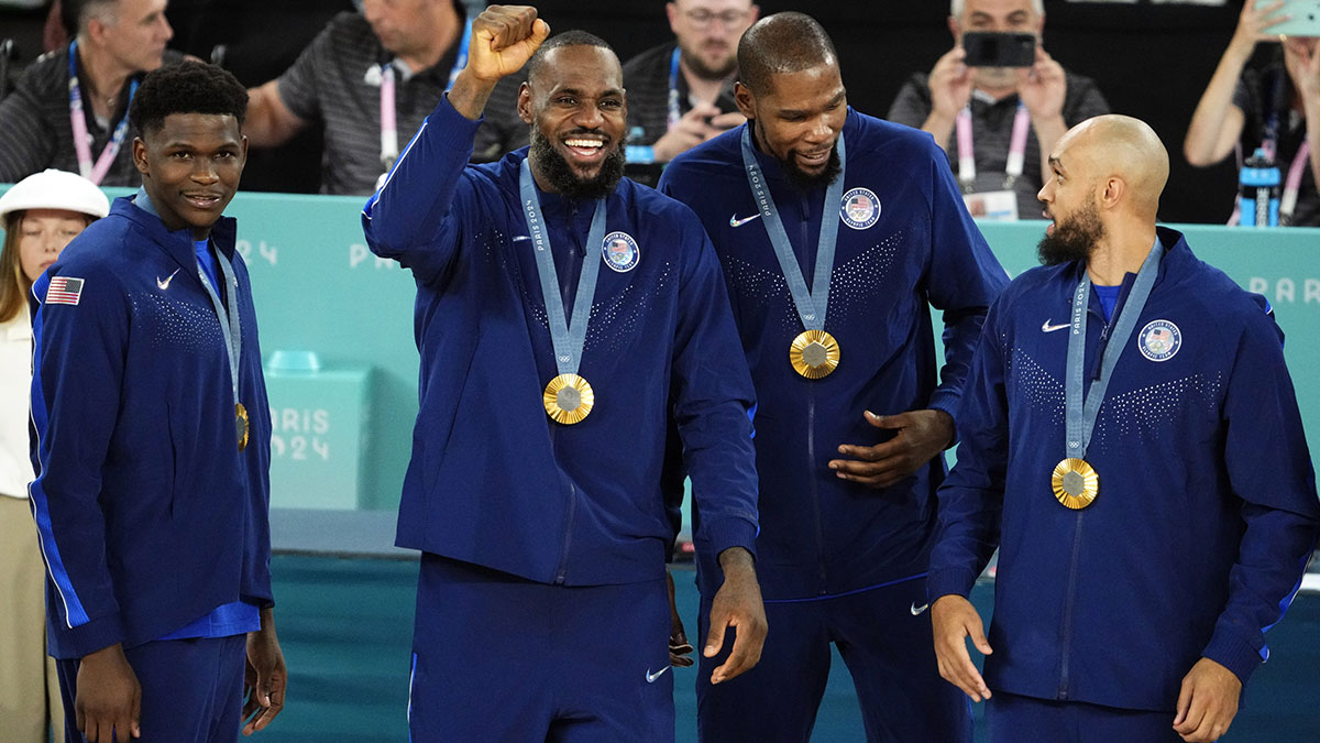 United States guard Anthony Edwards (5) and guard LeBron James (6) and guard Kevin Durant (7) and guard Derrick White (8) celebrate with their gold medals on the podium after defeating France in the men's basketball gold medal game during the Paris 2024 Olympic Summer Games at Accor Arena.