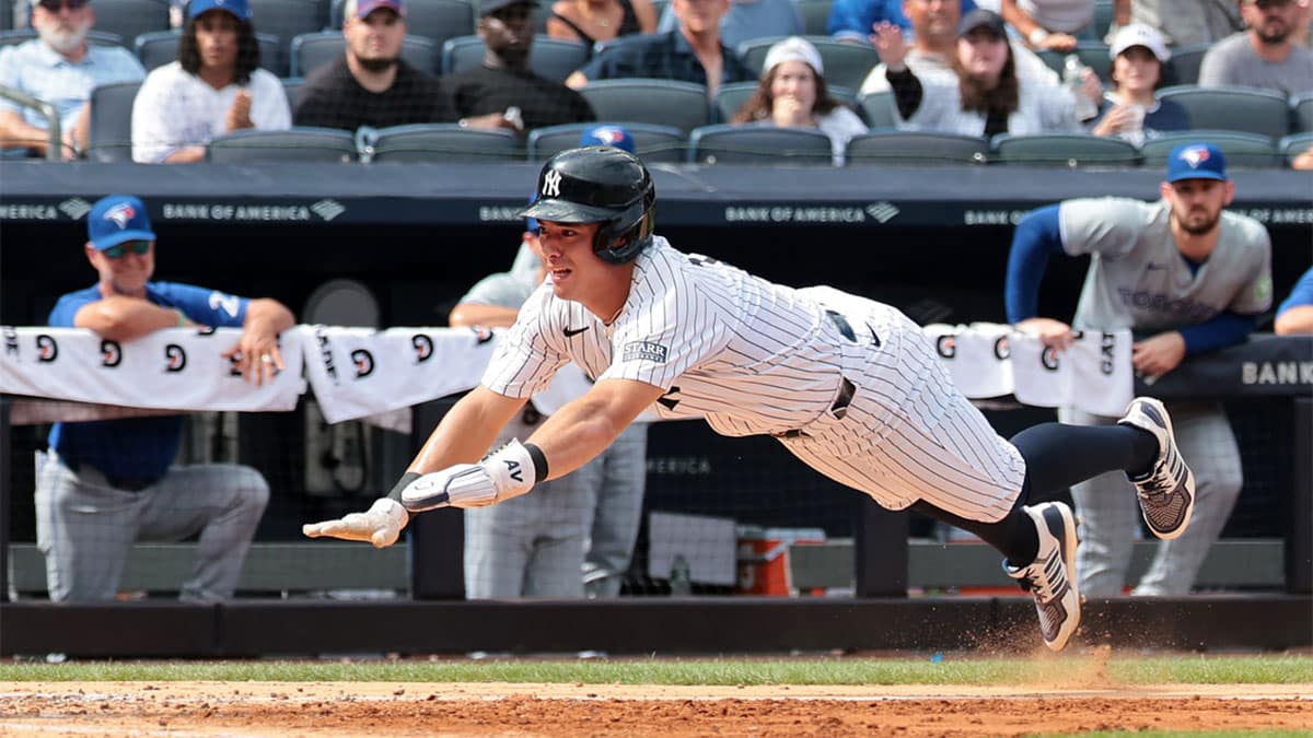 New York Yankees shortstop Anthony Volpe (11) scores a run on an RBI by third baseman DJ LeMahieu (26) sacrifice fly during the sixth inning against the Toronto Blue Jays at Yankee Stadium.