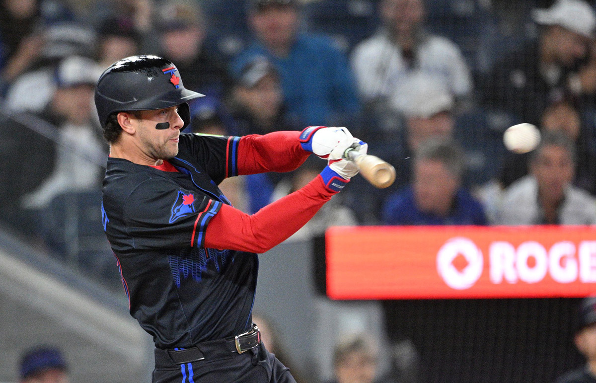 Toronto Blue Jays shortstop Ernie Clement (28) hits a double against the Cincinnati Reds in the seventh inning at Rogers Centre.