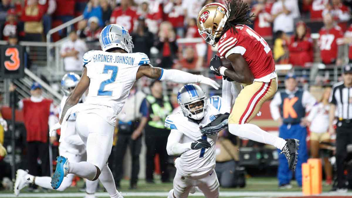 49ers wide receiver Brandon Aiyuk catches the ball around Lions defensive backs C.J. Gardner-Johnson, left, and Cam Sutton for a touchdown in the third quarter of the Lions' 34-31 loss in the NFC championship game in Santa Clara, California.