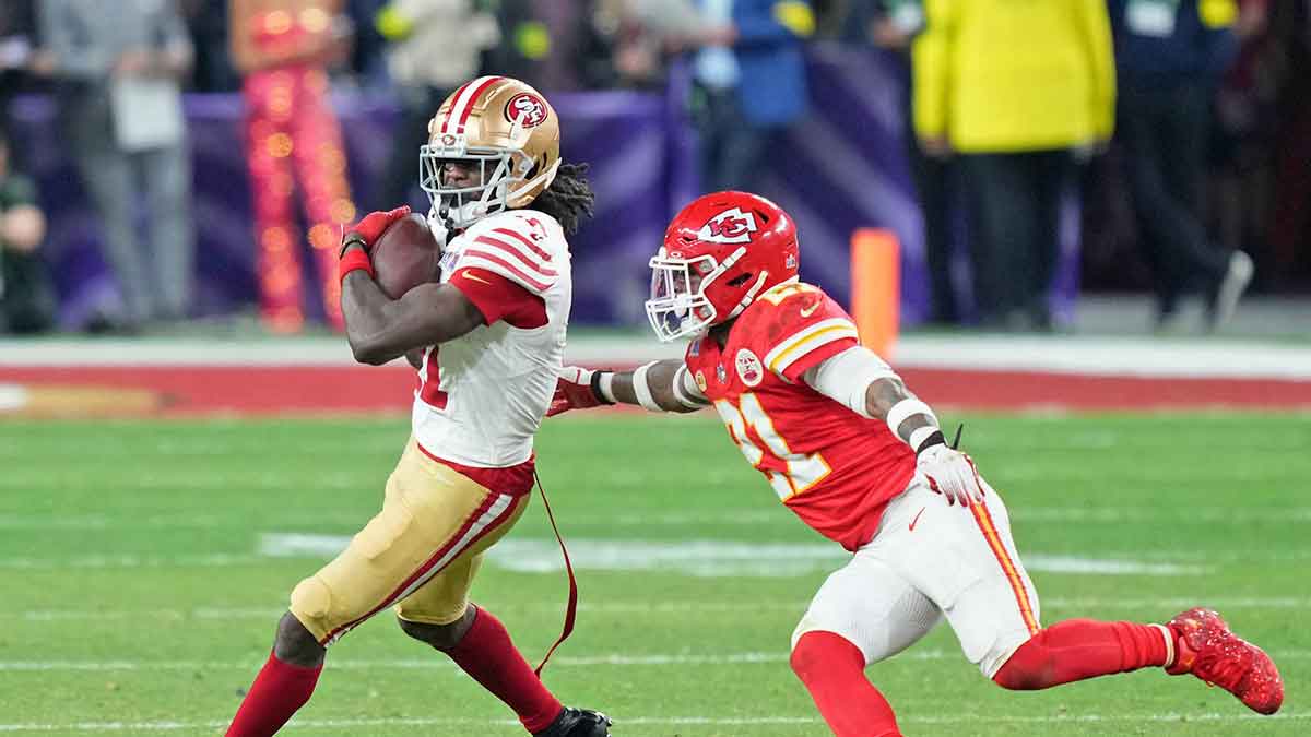 San Francisco 49ers wide receiver Brandon Aiyuk (11) makes a catch against Kansas City Chiefs safety Mike Edwards (21) during overtime of Super Bowl LVIII at Allegiant Stadium. 