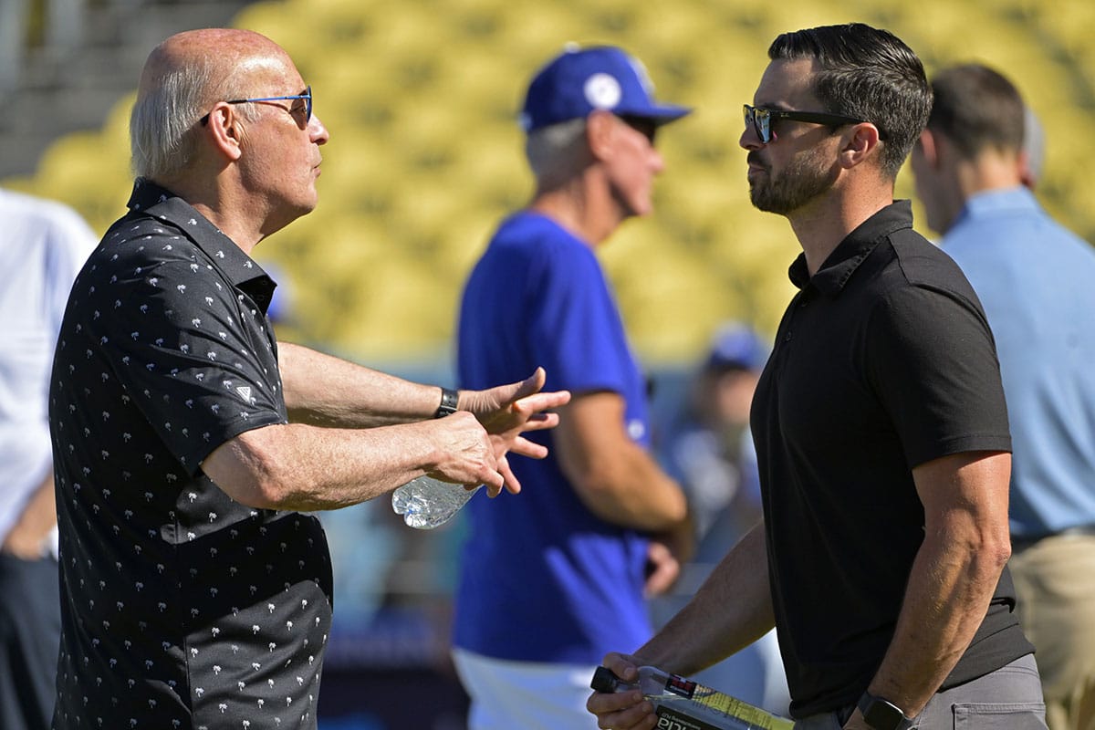 Los Angeles Dodgers President and CEO Stan Kasten talks with Executive Vice President and General Manager Brandon Gomes on the field prior to the game between the Los Angeles Dodgers and the Boston Red Sox at Dodger Stadium.