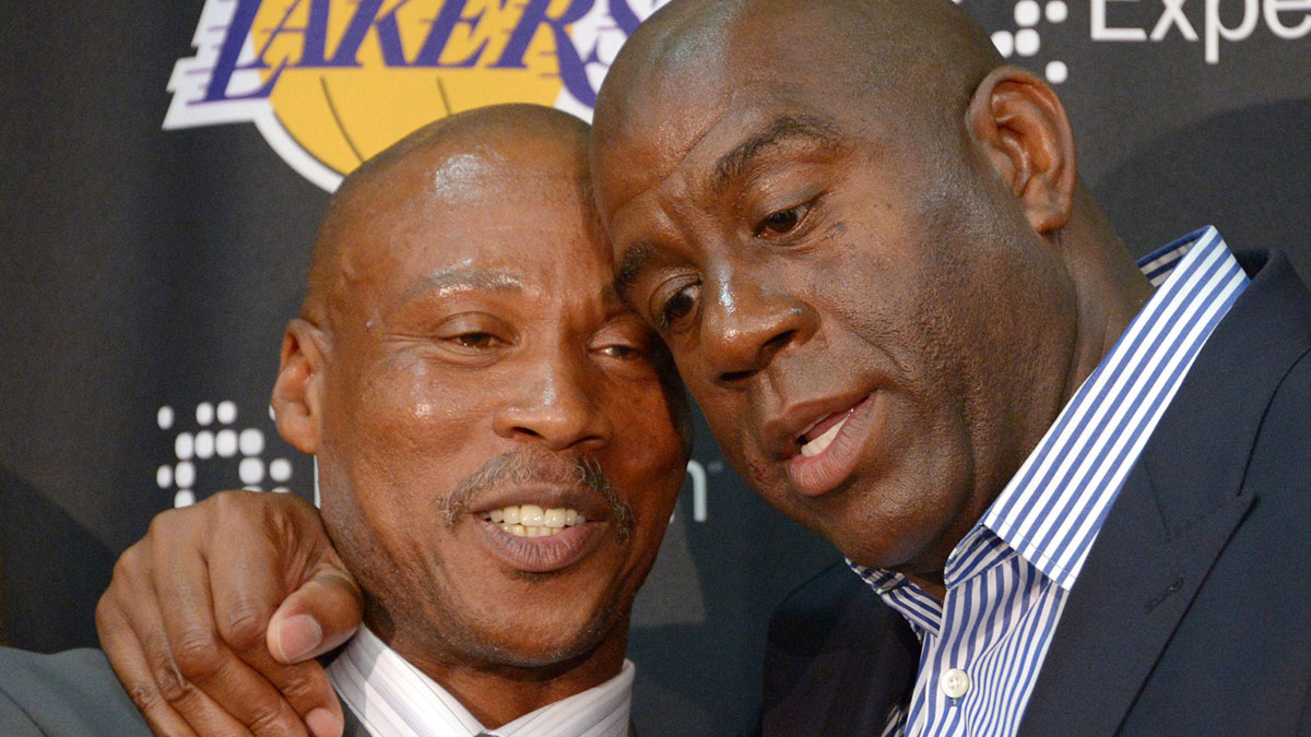 Byron Scott (left) is embraced by (GOAT PG candidate) Magic Johnson at a press conference to introduce Scott as Los Angeles Lakers coach at Toyota Sports Center