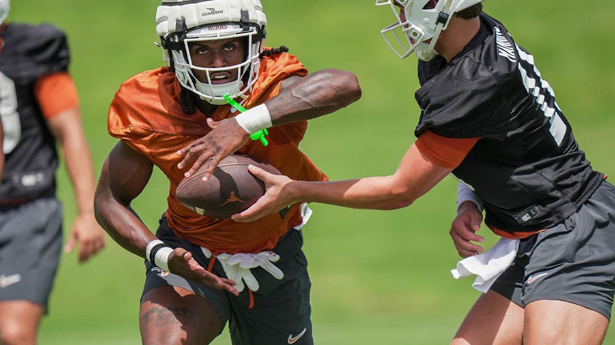 Texas Longhorns Arch Manning hands the ball of to CJ Baxter during the first fall football camp practice for the Texas Longhorns at Denius Fields.