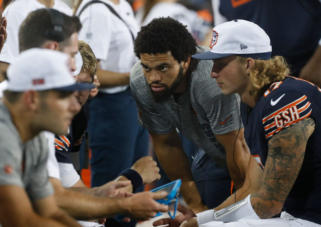 Chicago Bears quarterback Caleb Williams (RC) listens in the quarterback huddle on he sidelines against the Houston Texans during the third quarter at Tom Benson Hall of Fame Stadium.