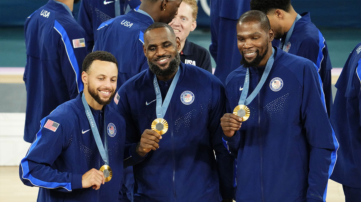 US shooting guard Stephen Curry (4), guards LeBron James (6) and Kevin Durant (7) celebrate with their gold medals on the podium after defeating France in the men's basketball game during the 2024 Summer Olympics in Paris at the Accor Arena.