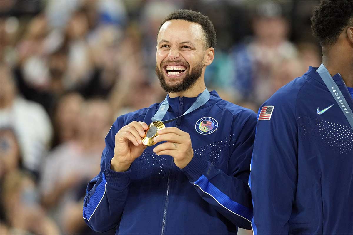 United States shooting guard Stephen Curry (4) celebrates with the gold medal after the game against France in the men's basketball gold medal game during the Paris 2024 Olympic Summer Games at Accor Arena