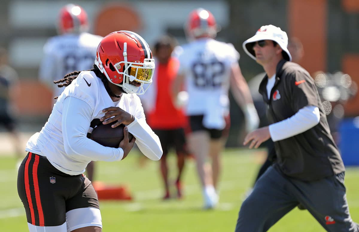 Browns running back D'Onta Foreman runs as offensive coordinator Ken Dorsey watches during minicamp.