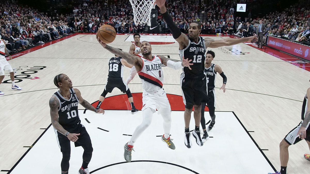 Portland Trail Blazers guard Damian Lillard (0) shoots the ball past San Antonio Spurs forward LaMarcus Aldridge (12) during the first half at Moda Center. 