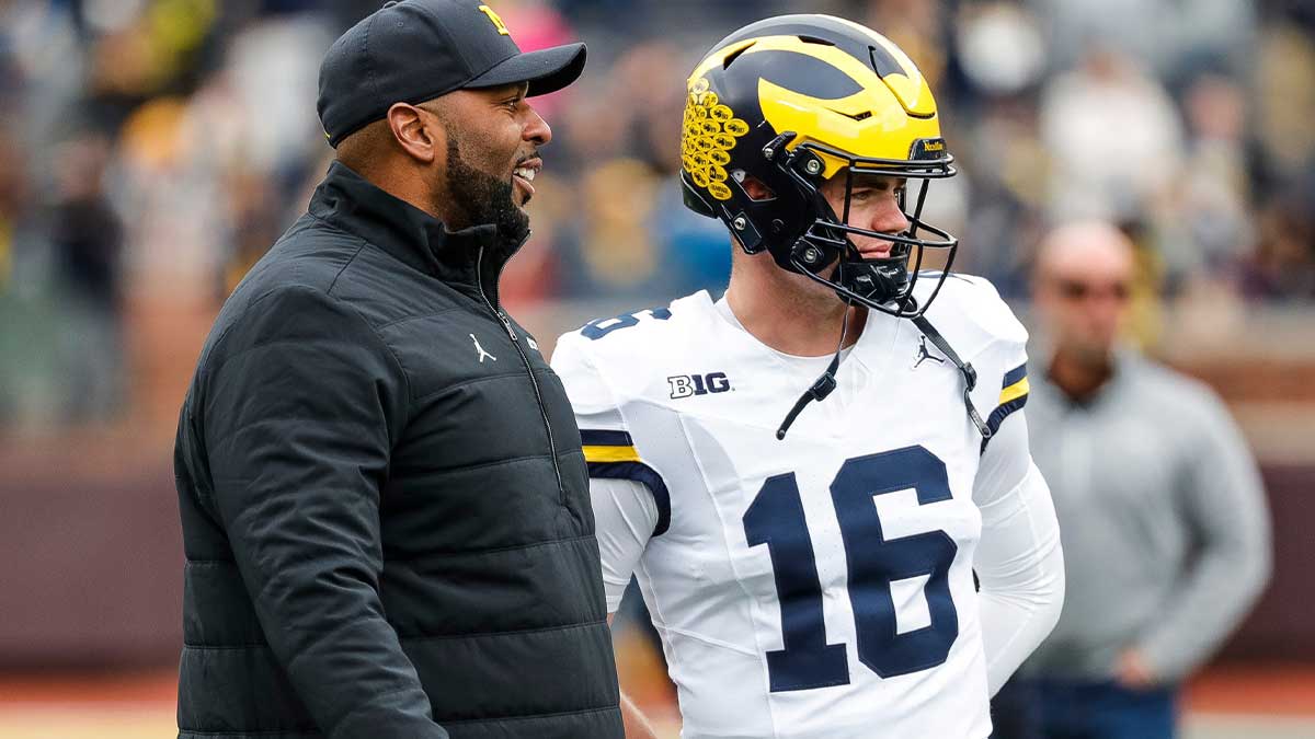 Michigan head coach Sherrone Moore talks to quarterback Davis Warren (16) at warmup during the spring game at Michigan Stadium