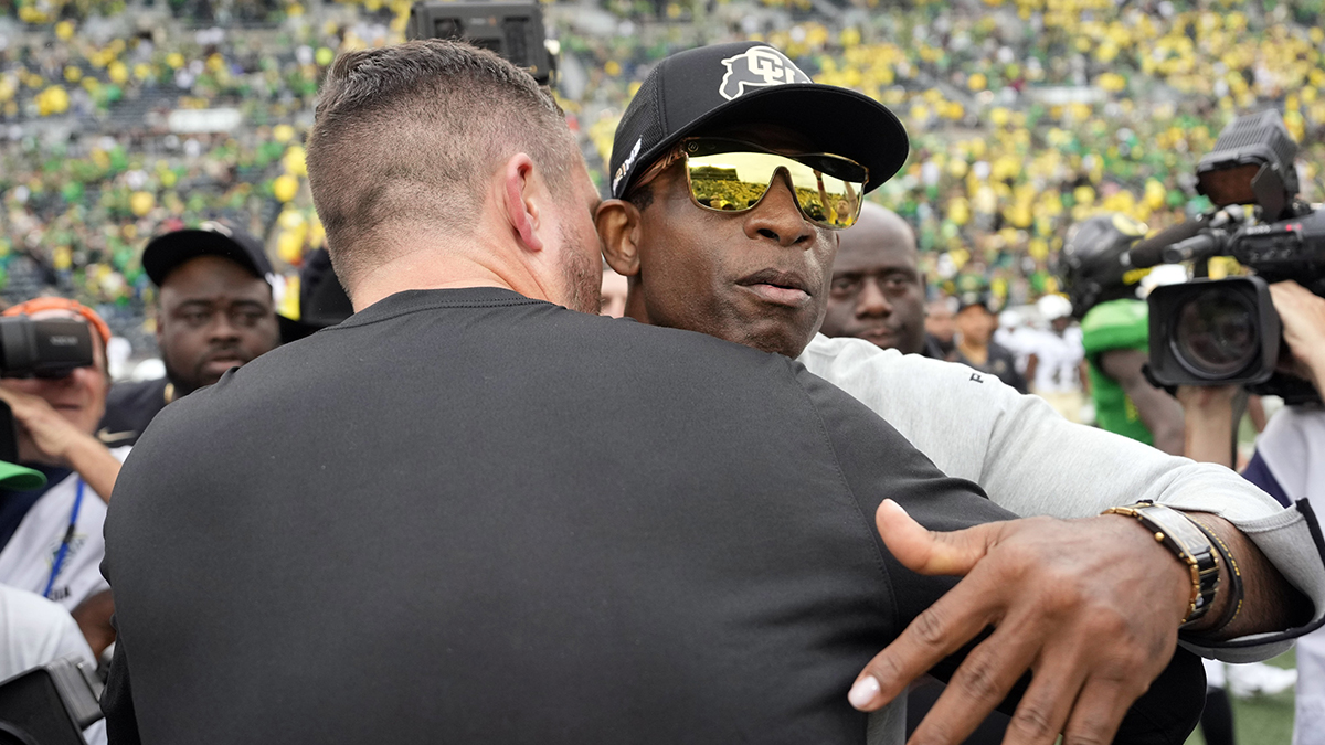 Oregon Ducks head coach Dan Lanning (left) and Colorado Buffaloes head coach Deion Sanders hug after the game at Autzen Stadium.