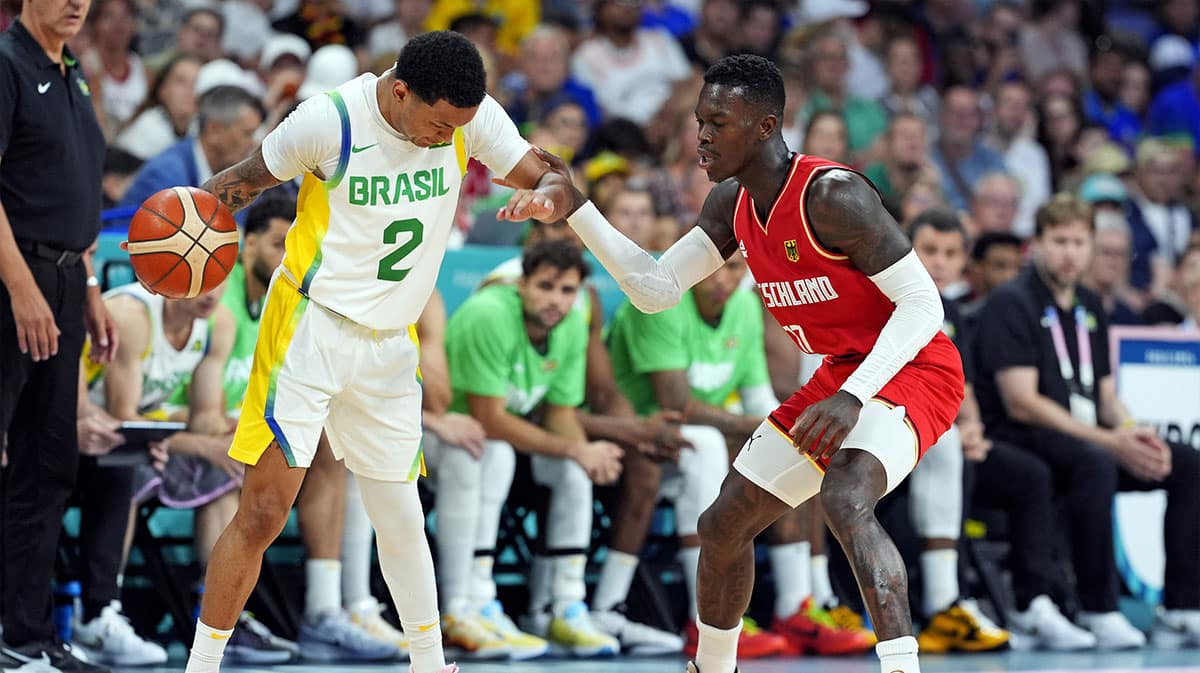 Brazil point guard Yago Santos (2) handles the ball against Germany point guard Dennis Schroder (17) in men’s basketball group B play during the Paris 2024 Olympic Summer Games at Stade Pierre-Mauroy.