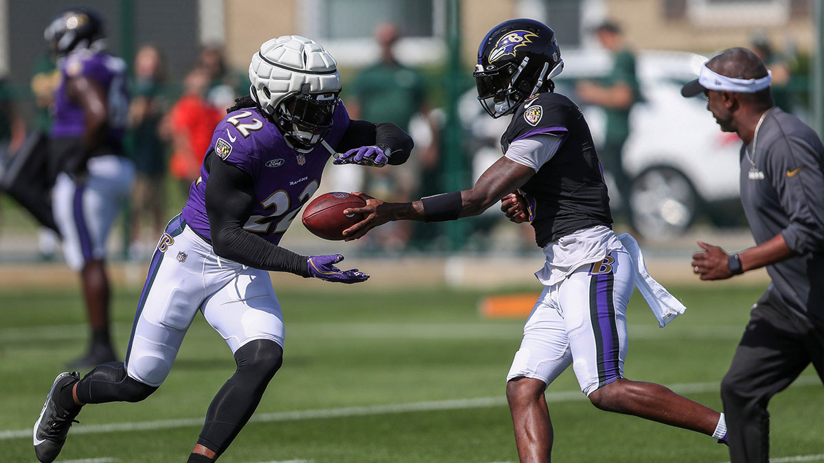 Baltimore Ravens running back Derrick Henry (22) takes a handoff from quarterback Lamar Jackson (8) during a joint practice with the Green Bay Packers