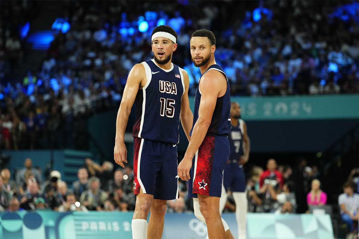 US guard Devin Booker (15) and shooting guard Stephen Curry (4) react in the second half against France in the men's basketball gold medal game during the 2024 Summer Olympics in Paris at Accor Arena.