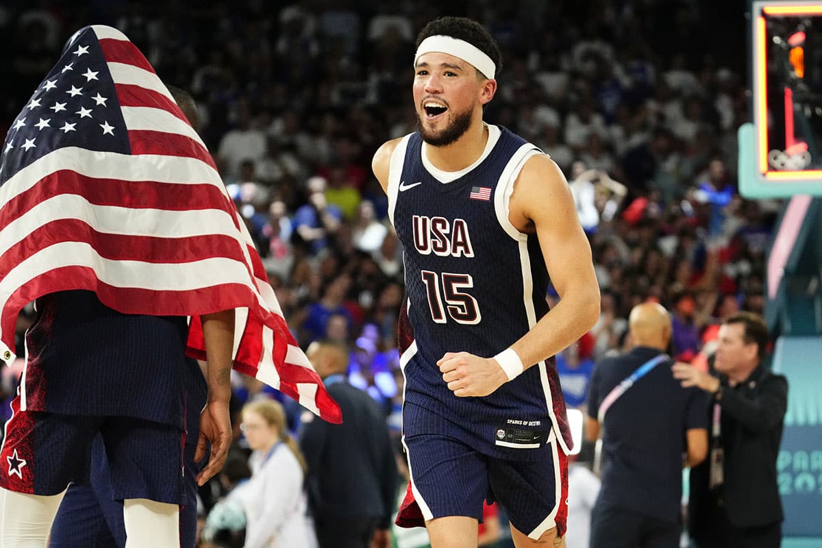 US guard Devin Booker (15) celebrates after defeating France in the men's basketball gold medal game during the 2024 Summer Olympics in Paris at Accor Arena. 