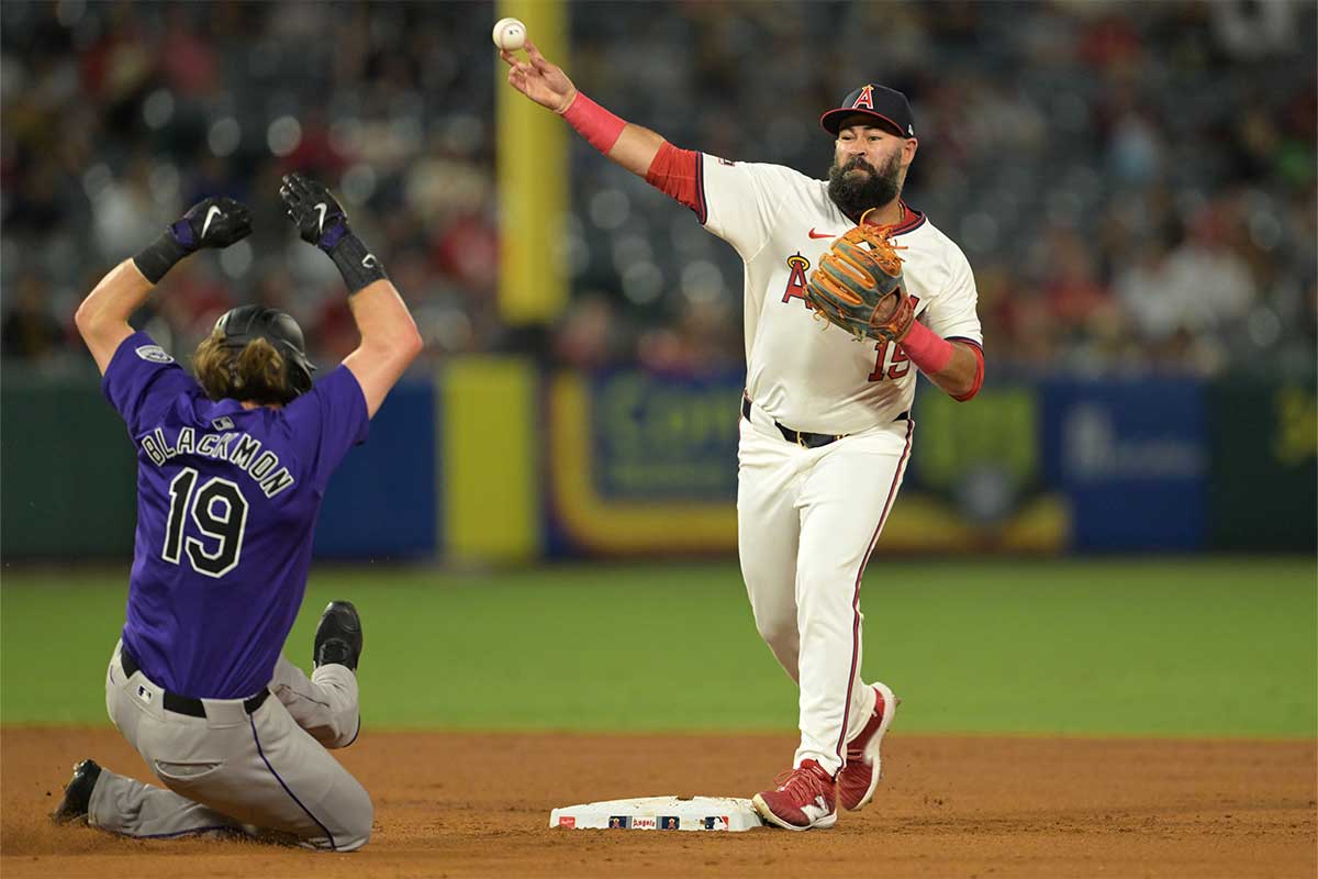 Los Angeles Angels second baseman Luis Guillorme (15) throws to first as Colorado Rockies designated hitter Charlie Blackmon (19) is out on a double play at Angel Stadium.
