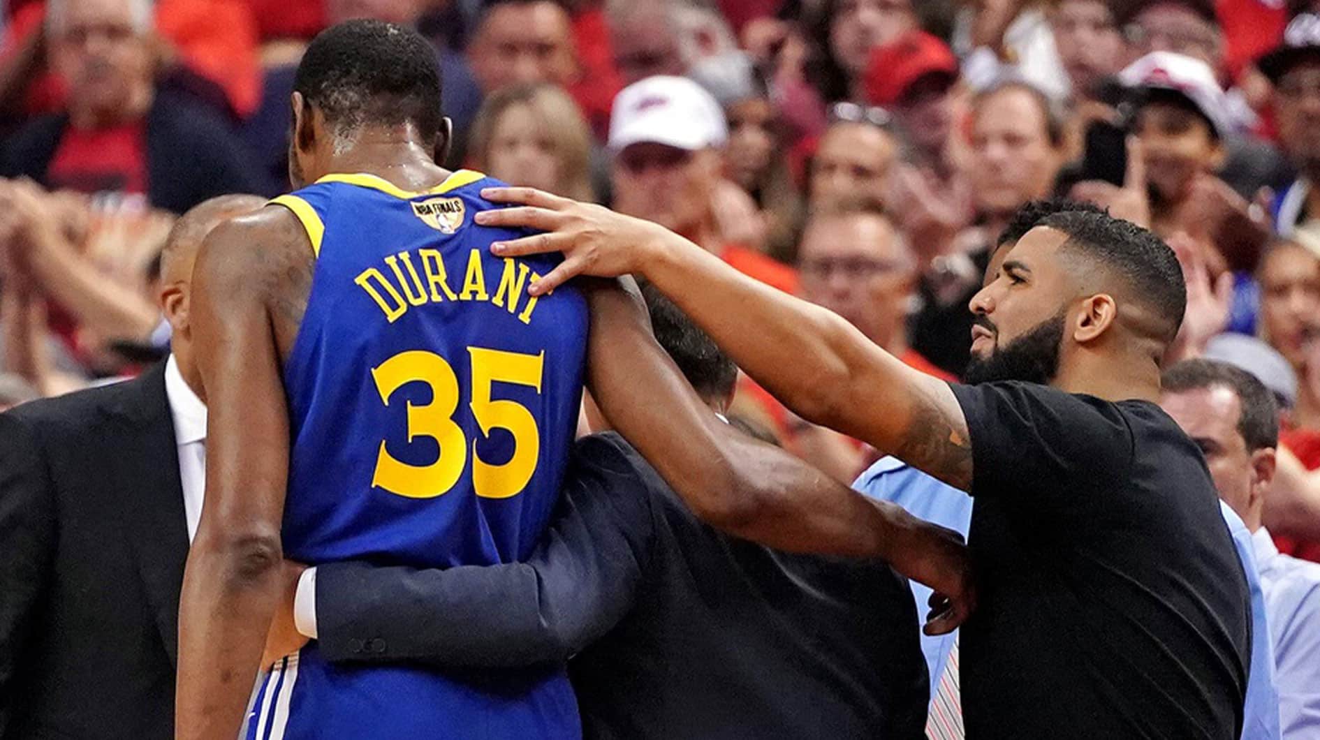 Recording artist Drake reacts with Golden State Warriors forward Kevin Durant (35) after an apparent injury during the second quarter against the Toronto Raptors in game five of the 2019 NBA Finals at Scotiabank Arena. 